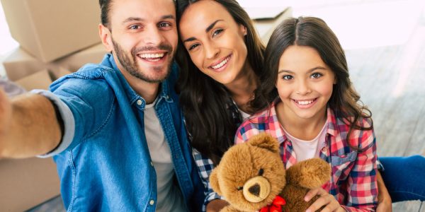 close-up-photo-joyful-family-is-taking-selfie-together-their-new-house-front-pile-cardboard-boxes